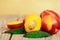 Whole and halves of red yellow nectarine, a bunch of peach on a wooden background with leaves. Harvest composition, fresh organic