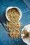 Whole hemp seeds in a white bowl, placer, blue background