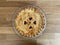 Whole homemade baked to a crisp apple pie, top view, decorated with hearth symbols.