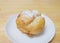 Whole homemade Japanese choux cream puff with icing on a small white plate