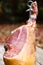 Whole jamon on a wooden stand on wooden table