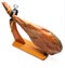 Whole leg of Spanish Iberian serrano ham in wooden support jamoneror. Isolated on white background