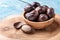 Whole nutmeg nuts in a bowl on blue rustic wooden table