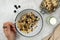 Whole oats breakfast, granola with dried fruit and blueberry, milk and honey. Hand holding the spoon. Copy space