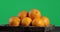 Whole oranges on a wooden tray rotate slowly.