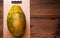 whole papaya on a wooden background. An imperfect-looking fruit with an uneven surface