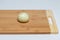 Whole peeled onions on a brown wooden kitchen board
