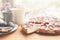 Whole plum cake with tea mugs, fresh plums and flowers on wooden