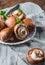 Whole raw fresh brown mushroom portobello on white plate.