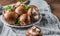 Whole raw fresh brown mushroom portobello on white plate.