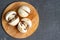 Whole raw fresh cultivated brown mushrooms, also known as champignons, on a wooden cutting board close-up