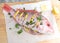 whole red snapper with lemon slices and parsley