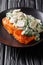 Whole salmon fillet is baked to perfection, then it`s finished with a topping of spinach, mushrooms, garlic and cream close up on
