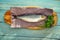 Whole salted fish herring on paper  wooden Board