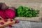 Whole and sliced beetroots and fresh parsley on a light cloth and on a wooden background. Vegetables from a garden.