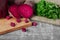 Whole and sliced beetroots, parsley and beverage on a cutting board and on a wooden background. Vegetables from a garden