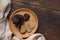 Whole and sliced black truffles mushroom on wooden plate on dark brown table, flat lay, copy space