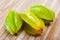 Whole and sliced fruits fresh carambola on table. Healthy vegetarian ingredient