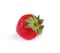 A whole strawberry isolated on a white background. A tasty red strawberry with bright green leaves. Healthful fruits concept.