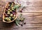 Whole table olives in the wooden bowl.