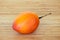 Whole tamarillo on a chopping board