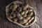 Whole tamarind fruits in wooden bowl