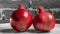 Whole two red pomegranate on black and white brick wall background. Garnet is a symbol of Judaism, top view.
