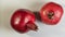 Whole two red pomegranates on white background. is a symbol of Judaism, fertility, abundance and marriage.