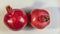 Whole two red pomegranates on white background. is a symbol of Judaism, fertility, abundance and marriage