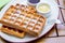 Whole wheat Belgium waffles on plate with butter, maple sauce on wooden table