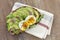 Whole wheat bread Avocado, poached egg sandwich with fresh herbs,red onion on dishcloth wooden board background. Healthy