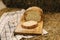 Whole wheat bread baked at home. Sliced bread on wooden board on hay. Bio ingredients