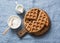 Whole wheat breakfast viennese waffles, cream and milk on blue background