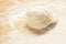 Whole wheat pizza dough shaped into ball on floured wooden background