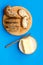 Wholegrain bread on cutting board with butter on plate, slice of bread with butter on blue background top view