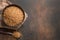 Wholegrain spelt farro in wooden bowl on brown background. Top view. Copy space