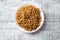 Wholegrain spelt fusilli on plate on white wooden background