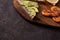 Wholegrain toast bread slices with guacamole, fried shrimp and fried bacon pieces on wooden board Selective Focus, Focus on the