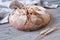 Wholemeal rye wheat bread oven baked in ceramic pan at home. No knead handmade loaf on cutting board on wood with linen