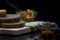 Wholewheat breads with cheese, jams and green olives on a wooden chopping board with their reflections, close up, macro