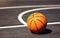Whos up for a game. Still life shot of a basketball on the ground in a sports court.