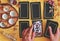 Wiccan witch reading the future at her altar using 5 card tarot spread on bright yellow cloth