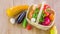 A wicker basket appears on a wooden table and is then filled with ripe vegetables and fruits. Stop motion animation