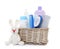Wicker basket with baby cosmetic products and knitted rabbit isolated