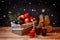 Wicker basket with bottles of wine, bottle of champagne,  christmas decorations and fruits. Mulled wine, candle and firewood