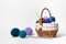 Wicker basket with colored balls of yarn for knitting or crocheting. Hobbies and recreation with needlework. On white background