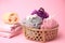 Wicker basket with colorful shower puffs on pink background