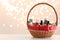 Wicker basket with cosmetics as present against blurred festive lights. Space for text