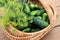 Wicker basket with cucumbers and dill branches, top view, close-up