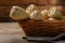 Wicker basket with delicious fresh ripe parsnips on wooden table, closeup